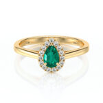 Bague en or avec une pierre précieuse en forme de poire couleur verte ornée de diamants scintillants, représentant l'élégance et le luxe. Parfaite pour des occasions spéciales, cette bague associe un design classique à une touche moderne, idéale pour les demandes en mariage ou comme pièce maîtresse de collection de bijoux.