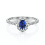 Bague en or blanc sertie d'un saphir en forme de poire, entouré de diamants sur toute la longueur de l'anneau, mettant en valeur un design élégant et sophistiqué, parfaite pour une proposition ou une occasion spéciale. Modèle + diamant.