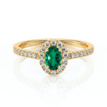 Bague en or jaune avec un élégant saphir vert oval entouré de diamants brillants, idéale pour une bague de fiançailles ou de mariage. Design raffiné et moderne, mettant en valeur le contraste entre le vert éclatant et l'or, parfait pour les amateurs de bijoux uniques et sophistiqués.