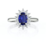 Bague en or blanc ornée d'un saphir ovale bleu vif, entouré de diamants scintillants, parfaite pour une proposition ou comme bijou de luxe. Modèle romantique avec un design élégant qui met en valeur la brillance des gemmes.