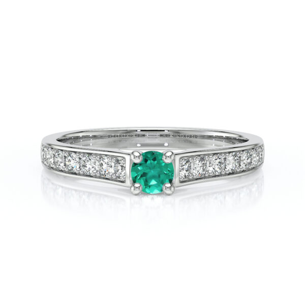 Bague en diamant et émeraude modèle élégant, présentant une pierre centrale en émeraude ronde entourée de diamants scintillants sur le band. Idéal pour les fiançailles ou comme bijou de luxe, cette bague met en avant un design raffiné et moderne, évoquant l'amour et l'exclusivité.