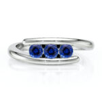 Bague en argent avec trois diamants bleu, présentation moderne de la joaillerie, design élégant et tendance, idéale pour des occasions spéciales, cadeau parfait pour anniversaires ou célébrations, bijou raffiné qui ajoute une touche de style.