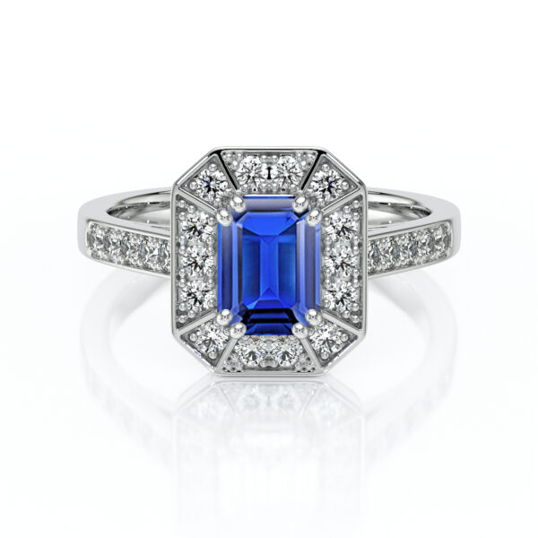 Bague en or blanc ornée d'une pierre précieuse en saphir bleu de taille émeraude, entourée de diamants scintillants, mettant en valeur un design élégant et moderne, idéale pour des fiançailles ou comme bijou de luxe.