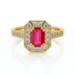 Bague en or avec une pierre précieuse centrale en rubis de coupe émeraude, entourée de diamants disposés en forme octogonale, sur une monture délicate ornée de diamants sur les côtés, parfaite pour les fiançailles ou un cadeau spécial.