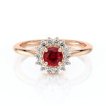 Bague en or rose ornée d'une pierre précieuse rouge entourée de diamants brillants, design élégant en forme de fleur, idéale pour les fiançailles ou comme bijou de luxe, modèle parfait pour un cadeau significatif.