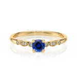 Bague en or avec une pierre précieuse en saphir bleu central entourée de diamants, modèle élégant et raffiné, idéale pour une proposition de mariage ou un bijou de tous les jours.