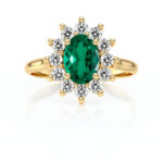 Bague en or avec un diamant central en forme ovale vert émeraude, entouré de brillant scintillant. Une pièce de bijouterie élégante qui combine le luxe et la sophistication. Idéale pour les fiançailles ou comme bijou de mode.