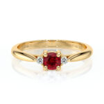 Bague en or jaune avec un rubis central, entouré de deux diamants scintillants, représentant un modèle élégant et raffiné parfait pour une demande en mariage ou une occasion spéciale.