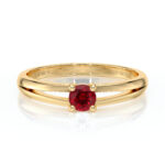 Bague en or jaune avec un design élégant, ornée d'une pierre précieuse ronde rouge vif au centre, parfaite pour une bague de fiançailles ou un cadeau spécial, reflétant le raffinement et l'amour. Modèle unique composé de deux bandes entrecroisées, mettant en valeur la brillance du diamant.