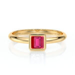 Bague en or jaune avec un sertissage en diamants, ornée d'un éclatant rubis de coupe émeraude, parfaite pour une proposition romantique ou un bijou de luxe. Cette bague raffinée met en valeur le rouge vibrant de la pierre précieuse, idéale pour les amateurs de joaillerie élégante et moderne.