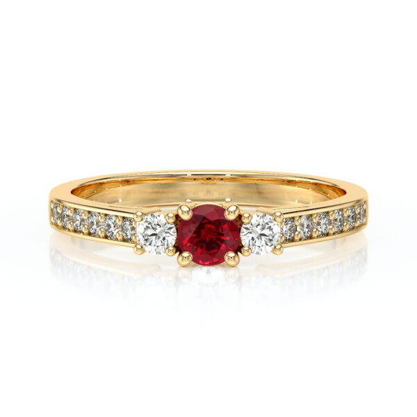 Bague en or jaune ornée d'un rubis central entouré de deux diamants ronds, avec un pavé de diamants sur l'anneau, symbole d'élégance et de luxe, idéal pour une déclaration d'amour ou un cadeau spécial.