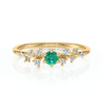 Bague en or avec un design élégant, ornée d'un cristal vert en son centre entouré de diamants scintillants, idéale pour les fiançailles ou les occasions spéciales, modèle unique avec diamant.