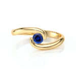 Bague en or jaune avec un design moderne et élégant, mettant en valeur un brillant saphir bleu rond. Idéale comme bijou de mariage, d'anniversaire ou pour une occasion spéciale, symbole d'amour et de raffinement. Modèle + diamant.