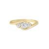 Bague en or jaune élégante avec trois diamants scintillants, dont un diamant central rond entouré de deux diamants plus petits, offrant un design moderne et harmonieux, parfait pour un engagement ou un cadeau spécial.