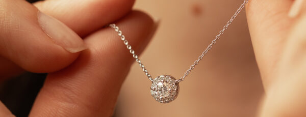Collier en argent avec pendentif en diamant, tenu délicatement par une main. Le pendentif brillant est orné de diamants scintillants, créant une allure élégante et sophistiquée. Idéal pour les occasions spéciales ou comme cadeau précieux. Modèle avec diamant - parfaite combinaison d'élégance et de luxe.